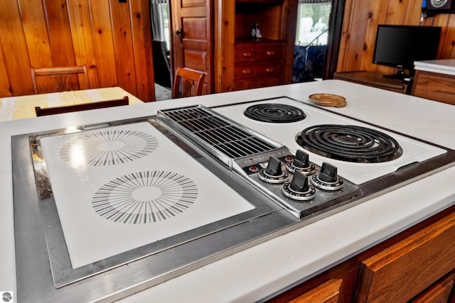 kitchen with brown cabinetry, stovetop with downdraft, and light countertops