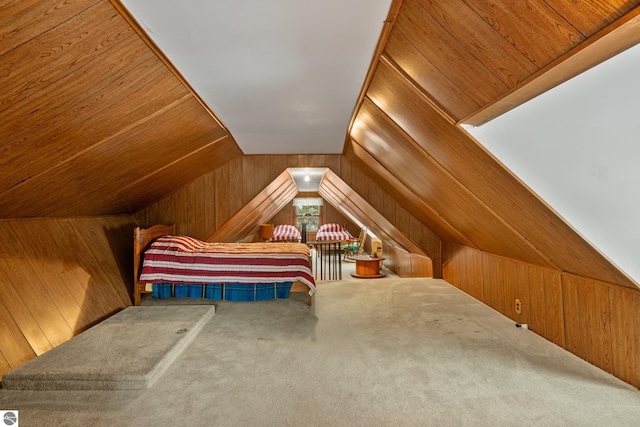 bedroom featuring lofted ceiling, wood walls, and carpet floors