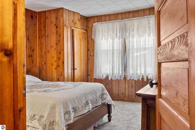 bedroom featuring carpet floors and wood walls