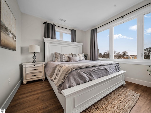 bedroom with dark hardwood / wood-style flooring