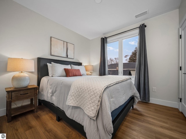 bedroom with dark hardwood / wood-style flooring