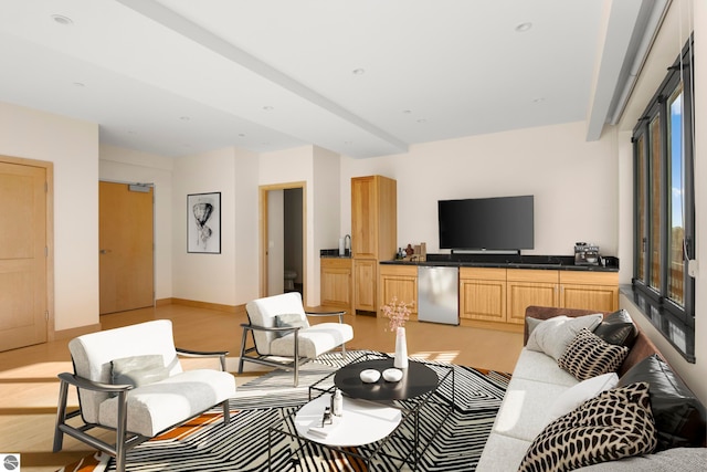 living room featuring beamed ceiling and light hardwood / wood-style floors