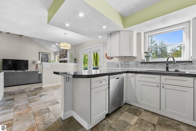 kitchen featuring kitchen peninsula, stainless steel dishwasher, sink, white cabinetry, and hanging light fixtures