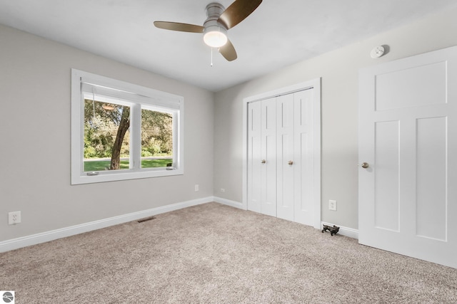 unfurnished bedroom with carpet floors, a closet, and ceiling fan