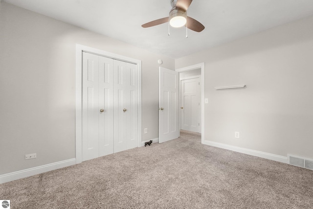 unfurnished bedroom featuring carpet, a closet, and ceiling fan