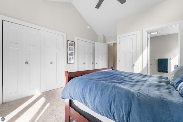 carpeted bedroom featuring multiple closets, ceiling fan, and vaulted ceiling