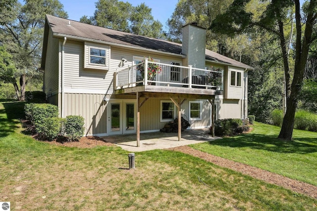 rear view of house with a yard, a patio, and a wooden deck