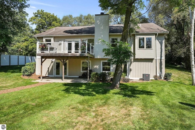 rear view of house featuring central air condition unit, a yard, and a wooden deck