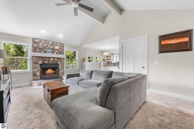 tiled living room with vaulted ceiling with beams, ceiling fan, and a fireplace