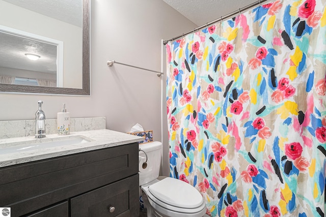 bathroom with vanity, curtained shower, toilet, and a textured ceiling