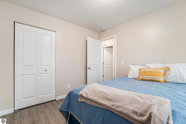 bedroom featuring hardwood / wood-style flooring, a textured ceiling, and a closet