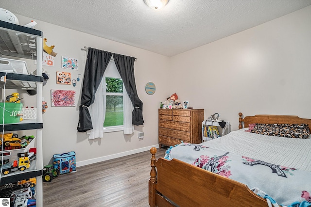 bedroom with hardwood / wood-style flooring and a textured ceiling