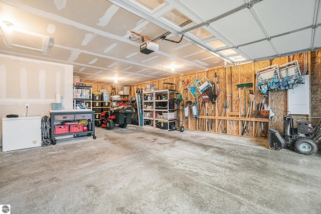 garage with refrigerator and a garage door opener