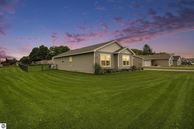 property exterior at dusk featuring a yard and a garage