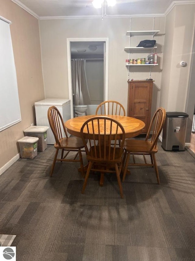 carpeted dining room featuring ornamental molding