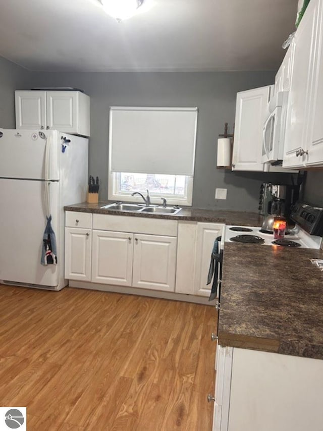 kitchen with white cabinetry, white appliances, sink, and light hardwood / wood-style flooring