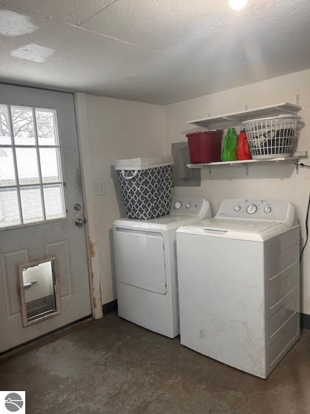 clothes washing area featuring washing machine and clothes dryer and a textured ceiling