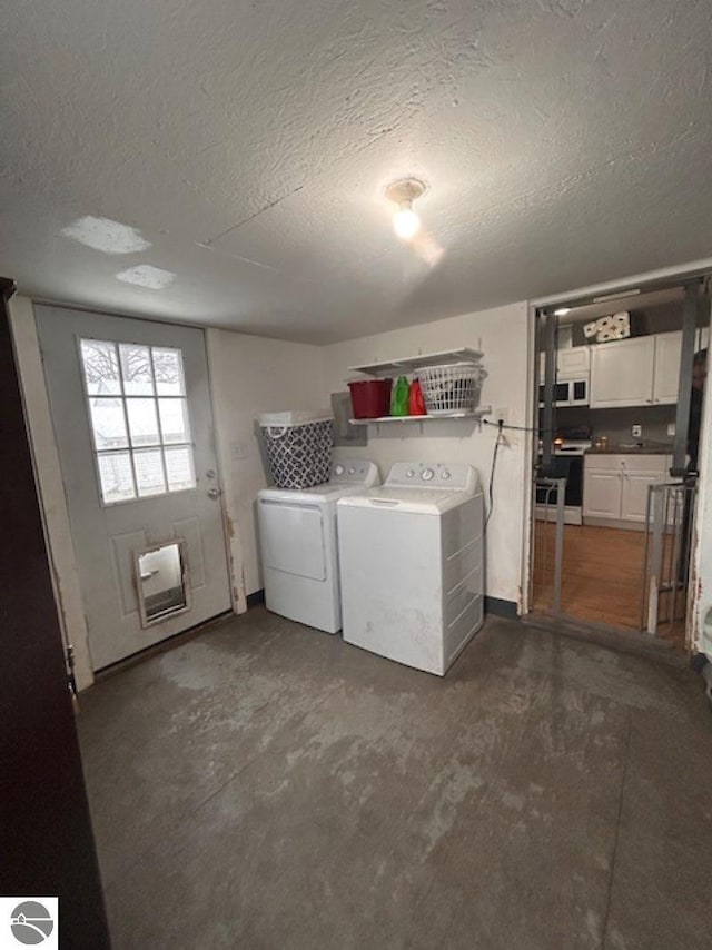 laundry room featuring a textured ceiling and washing machine and clothes dryer