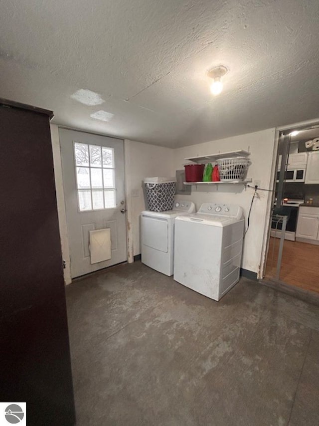 laundry room with washing machine and dryer and a textured ceiling