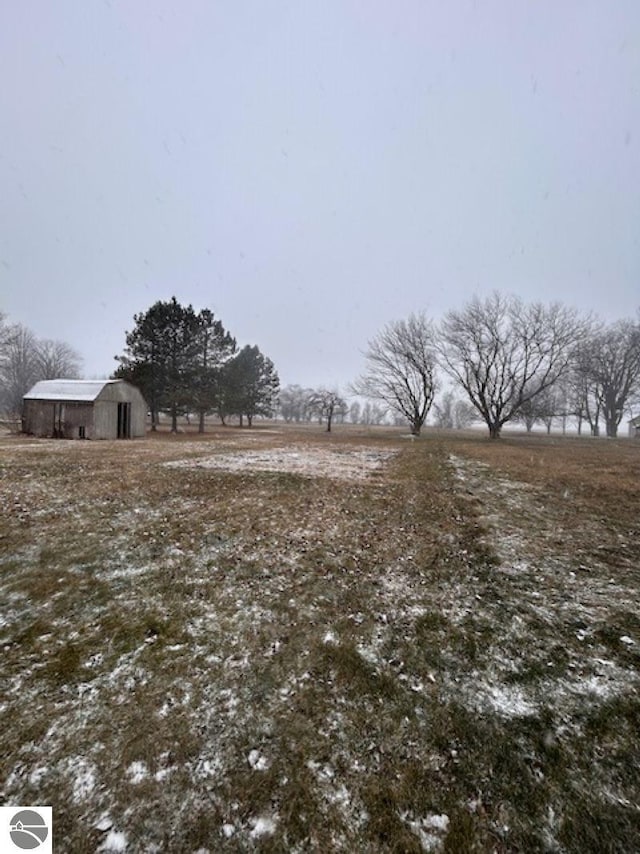 view of yard with a rural view and an outdoor structure