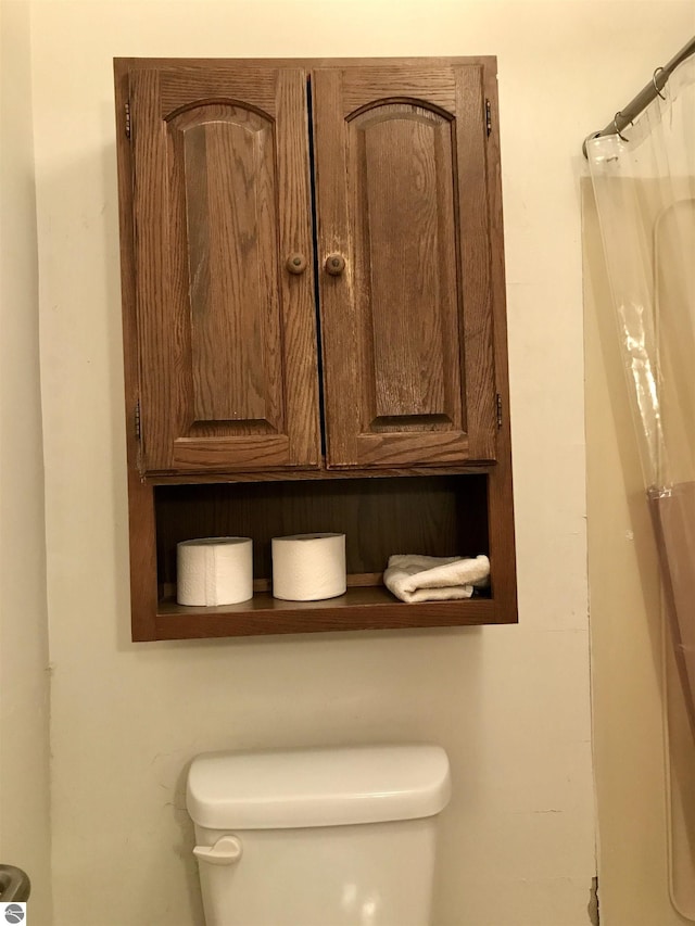 bathroom with toilet and curtained shower