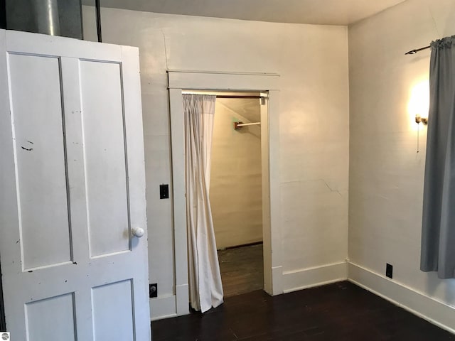 unfurnished bedroom with dark wood-type flooring