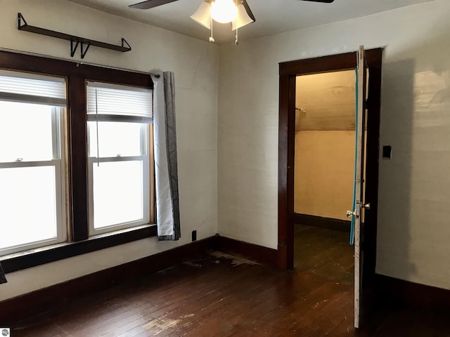 empty room with dark wood-type flooring and ceiling fan