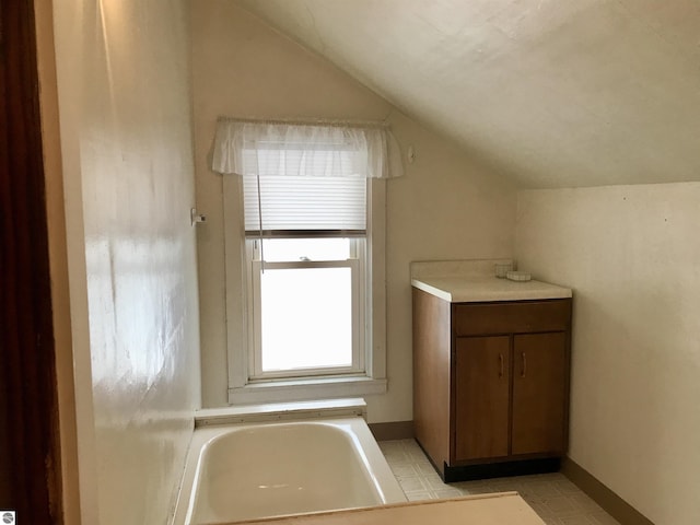 bathroom with a bathing tub and vaulted ceiling