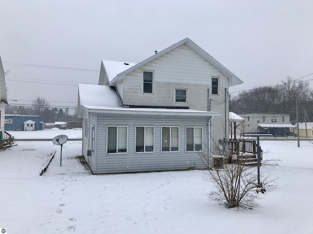 view of snow covered rear of property