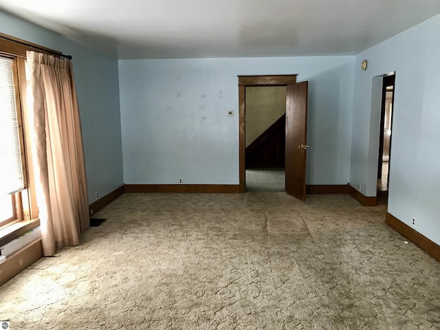 unfurnished room featuring light colored carpet and a wealth of natural light