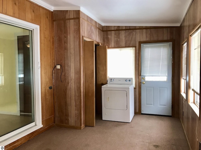 washroom featuring light carpet, washer / dryer, and wooden walls