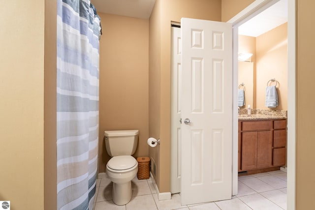 bathroom with toilet, vanity, and tile patterned floors