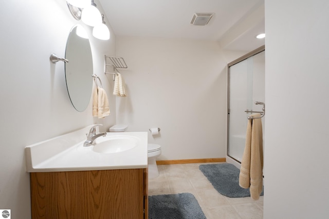 bathroom featuring tile patterned floors, vanity, toilet, and a shower with shower door