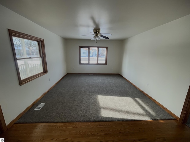 unfurnished room featuring dark hardwood / wood-style floors and ceiling fan