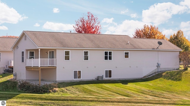 back of house with cooling unit and a lawn