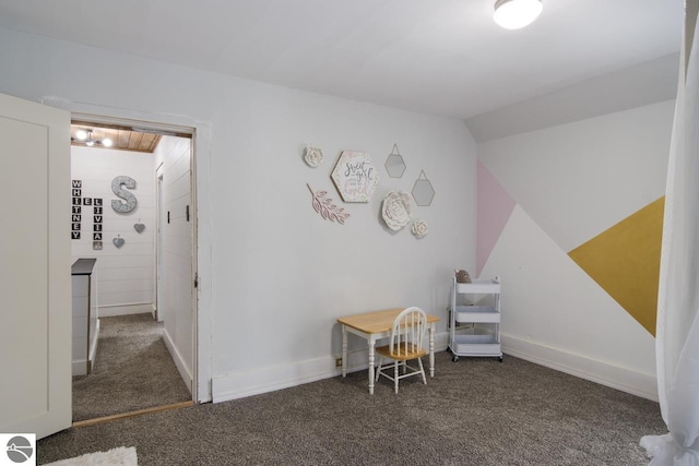 recreation room featuring dark carpet and lofted ceiling