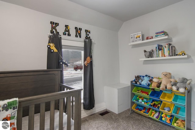 bedroom featuring carpet flooring, lofted ceiling, and a crib