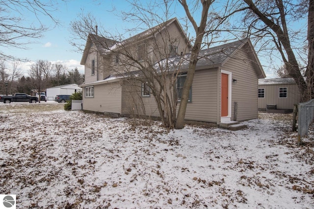 view of snow covered rear of property