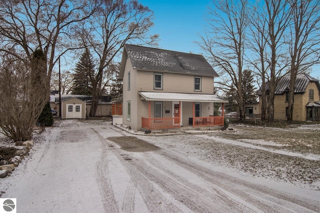 view of front of home featuring a porch and a storage shed