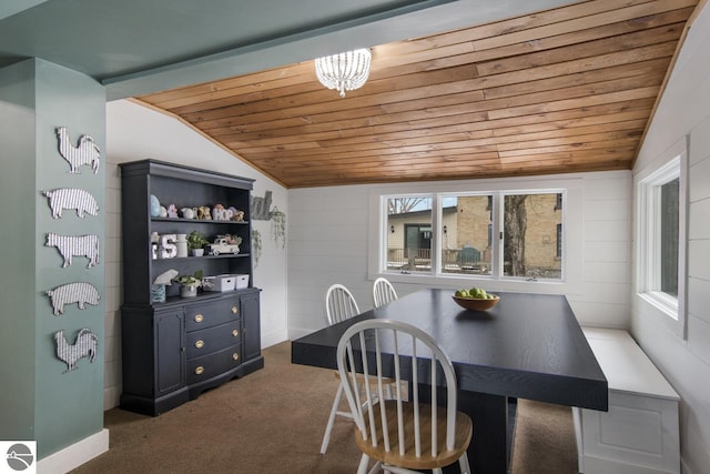 dining room with dark colored carpet, wooden ceiling, and vaulted ceiling