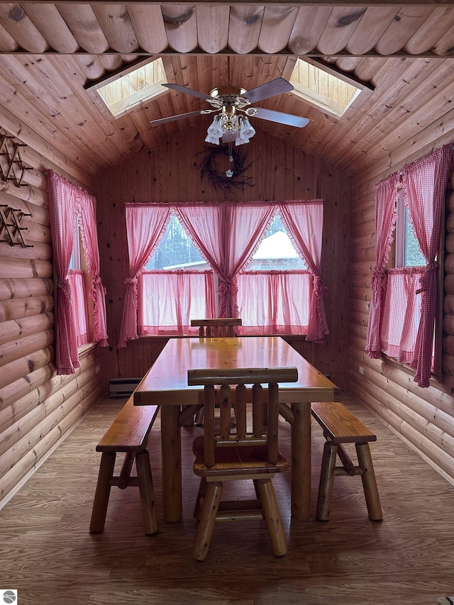 unfurnished dining area with hardwood / wood-style flooring, lofted ceiling with skylight, log walls, and a baseboard radiator