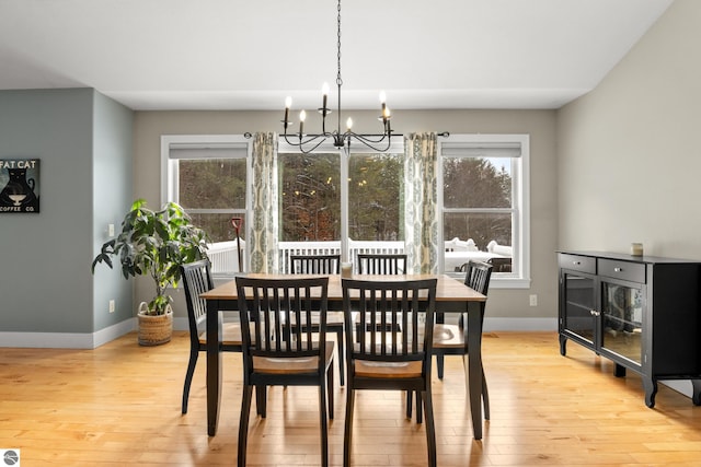 dining area with an inviting chandelier, a wealth of natural light, and light hardwood / wood-style flooring