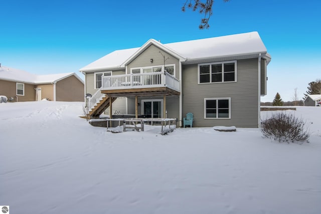 snow covered rear of property featuring a wooden deck