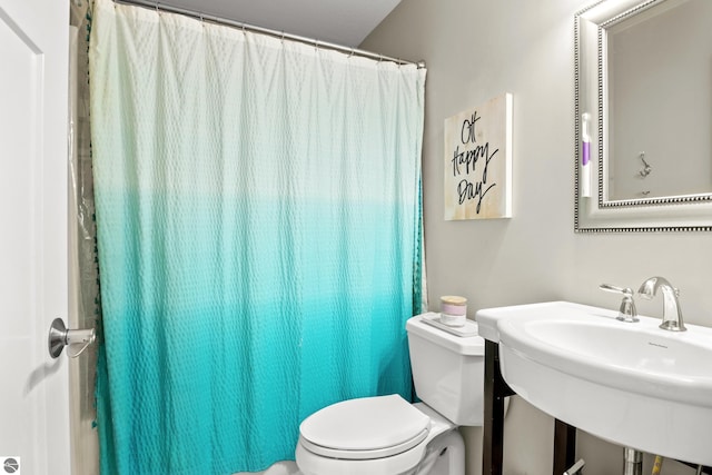 bathroom with sink, curtained shower, and toilet