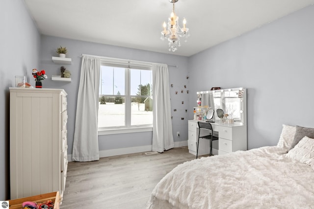 bedroom with a chandelier and light hardwood / wood-style floors