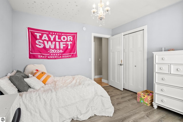 bedroom featuring light wood-type flooring, a closet, and an inviting chandelier