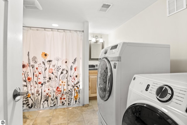 laundry area with washer and dryer and light tile patterned floors