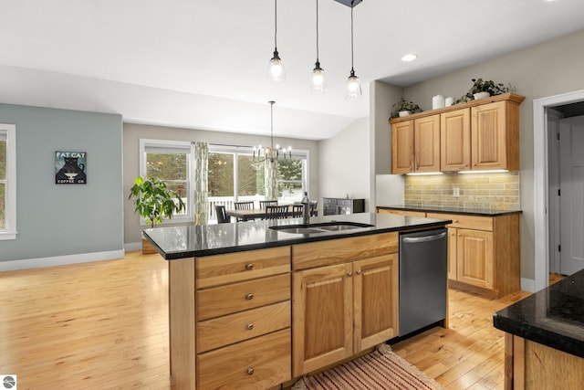 kitchen with sink, dishwasher, an island with sink, backsplash, and a chandelier