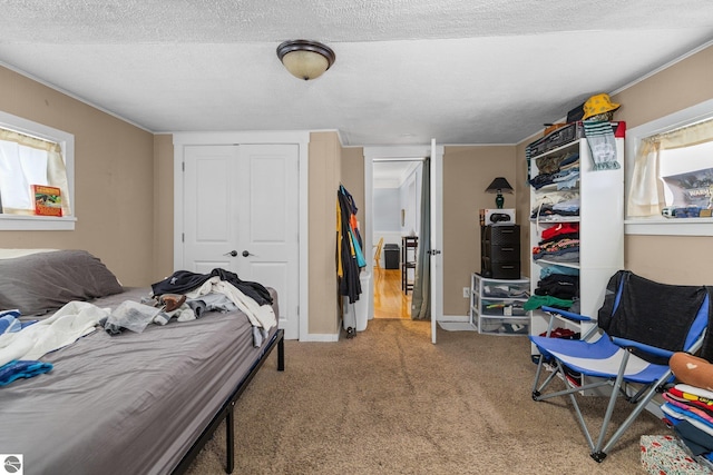 carpeted bedroom featuring a textured ceiling and a closet