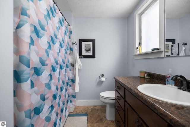 bathroom featuring a textured ceiling, a shower with shower curtain, vanity, and toilet